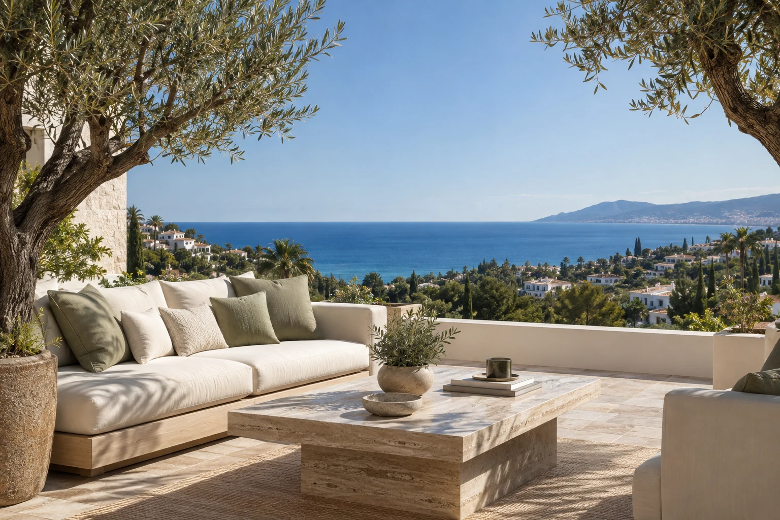 Olive trees and a cream outdoor sofa overlooking the coast